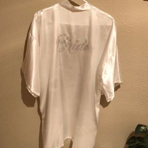 Satin knee length robe. “Bride” is bedazzled on the back. Matching sash tie.